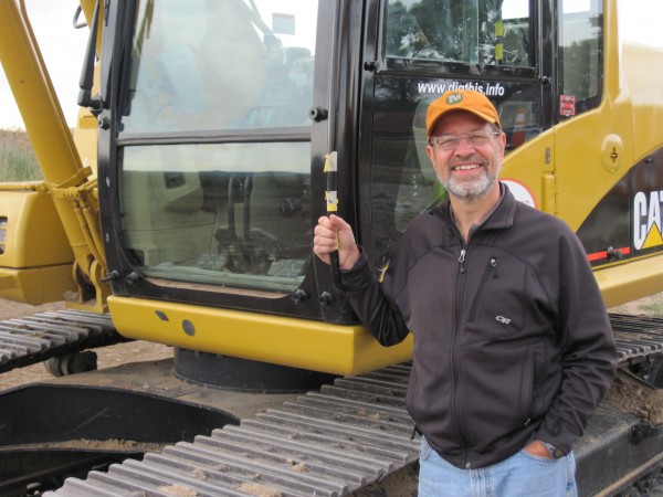 denver dig trip 022 Last September, Lloyd received a half-day gift certificate for DigThis, in honor of his graudation from UST. It took almost a year for us to find the best opportunity for him to use his gift certificate. Today was the day. He's standing by his excavator here, just before Gary, his guide, began the machine orientation.